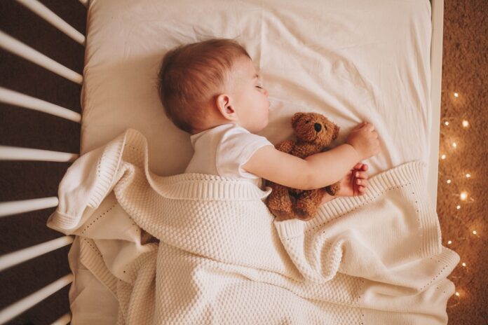 A,Little,Baby,In,A,White,Bodysuit,Sleeping,In,A